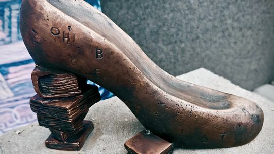 Rzeźba buta z brązu ustawiona przed Miejską i Gminną Biblioteką Publiczną w Krapkowicach