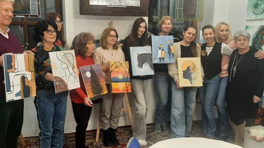 Uczestnicy spotkania „nieWinne malowanie” podczas wspólnego malowania obrazów przy sztalugach w Galerii Studnia