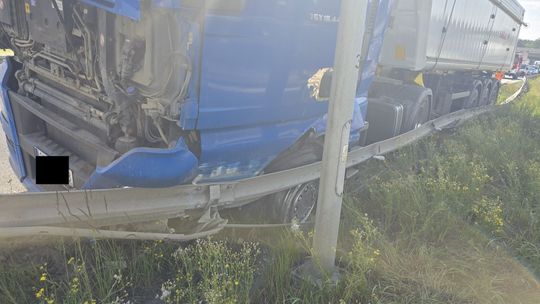 Ciężarówka marki MAN z kruszywem po zderzeniu z barierami na autostradzie A4 – strażacy i policja na miejscu zdarzenia.