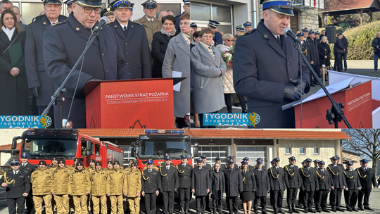 Uroczyste przekazanie obowiązków komendanta w Komendzie Powiatowej PSP w Krapkowicach, strażacy w galowych mundurach i poczet sztandarowy