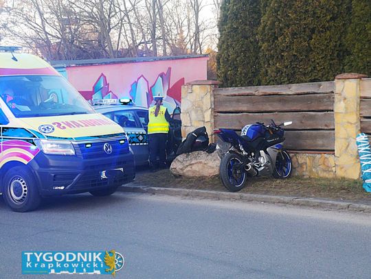Motocykl marki Yamaha leżący na jezdni na osiedlu Sady w Otmęcie, obok ratownicy medyczni udzielający pomocy 17-latkowi
