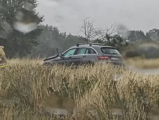 Samochód osobowy poza jezdnią po kolizji na autostradzie A4 w kierunku Katowic. Na miejscu pracują policjanci i strażacy.