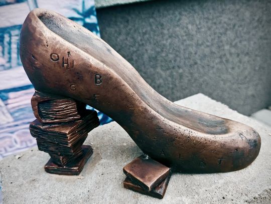 Rzeźba buta z brązu ustawiona przed Miejską i Gminną Biblioteką Publiczną w Krapkowicach