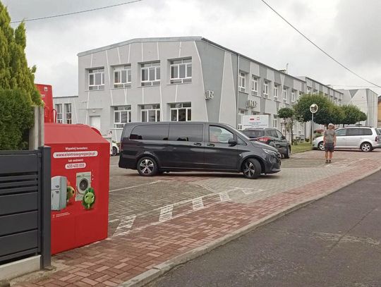 Czerwony pojemnik na elektroodpady ustawiony przy szkole w Malni, widoczny punkt zbiórki małego sprzętu
