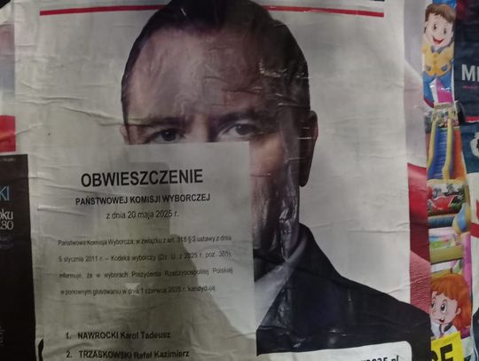 Zniszczony plakat wyborczy Karola Nawrockiego zaklejony obwieszczeniem PKW
