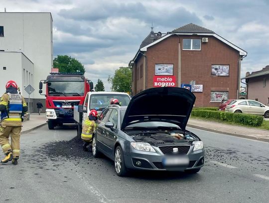 Rozsypany węgiel na drodze w centrum Krapkowic po kolizji ciężarówki z samochodem osobowym, obecność służb ratunkowych. Tygodnik Krapkowicki