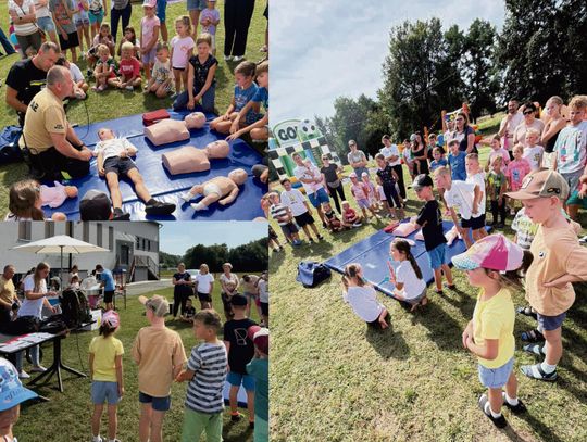 Dzieci bawiące się na kolorowych dmuchańcach podczas Festiwalu Dmuchańców w Walcach, obok stanowisk edukacyjnych dotyczących reagowania na sygnały alarmowe.