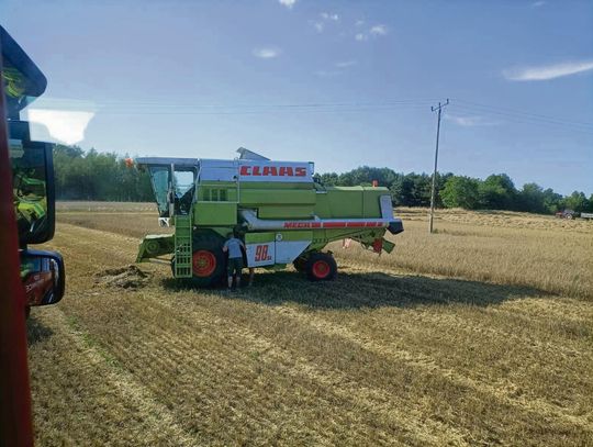 Strażacy przy kombajnie po pożarze w Komornikach — działania schładzające miejsce zapłonu
