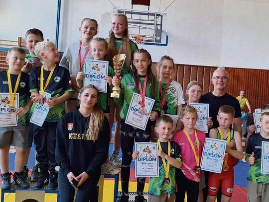 Zapaśnicy ZKS Gogolin podczas zawodów, pozujący z medalami