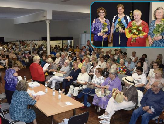 Seniorzy uczestniczący w zebraniu sprawozdawczo‑wyborczym UTW w Krapkowicach, w sali wypełnionej słuchaczami.