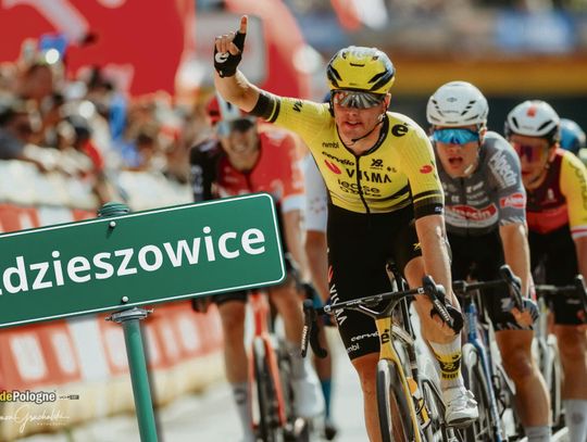 Peleton zawodowych kolarzy przejeżdżający przez miejscowość na trasie wyścigu