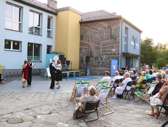 Plenerowy koncert „Kultura w promieniach lata” na skwerze przy bibliotece w Krapkowicach z muzykami, tancerzami tanga i publicznością.