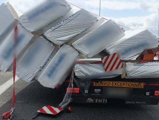 Ciężarówka i rozsypany ładunek na autostradzie A4 w rejonie węzła Krapkowice. Na miejscu pracują policjanci i służby zabezpieczające miejsce zdarzenia.