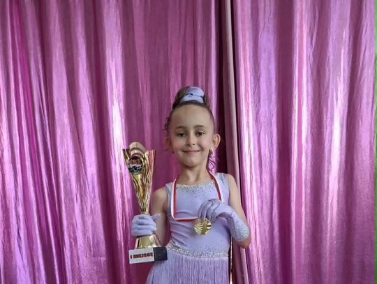 Tancerki Rising Stars i Gold Stars z gminy Strzeleczki podczas zawodów tanecznych, świętujące sukcesy na podium mistrzostw Polski.