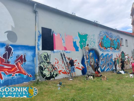Artysta malujący wielkoformatowy mural inspirowany postaciami Marvela na ścianie budynku w Otmęcie podczas wydarzenia street art.