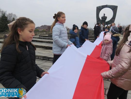 Na zdjęciu Mieszkańcy Zdzieszowic z biało-czerwonymi flagami świętują 11 listopada przy pomniku Powstańca Śląskiego podczas obchodów Święta Niepodległości 2025.