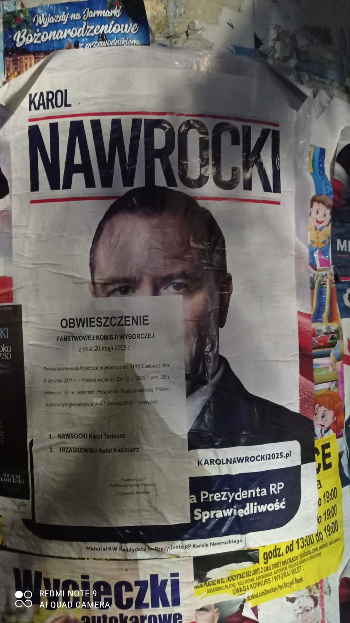 Zniszczony plakat wyborczy Karola Nawrockiego zaklejony obwieszczeniem PKW