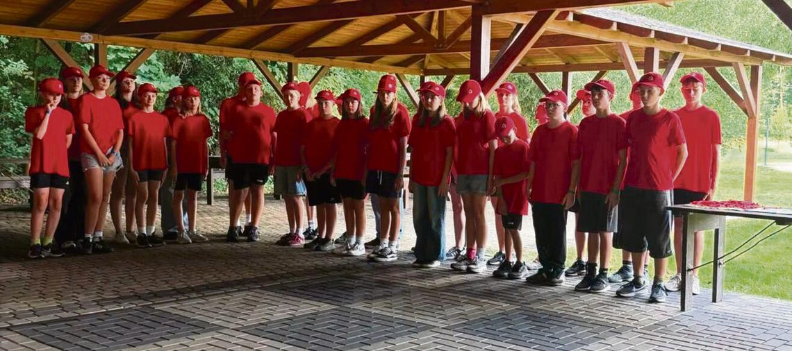 Obóz MDP w Dobrej zakończony! Rywalizacja czterech drużyn, olimpiada i wielkie emocje młodych strażaków „Młodzieżowe Drużyny Pożarnicze podczas olimpiady obozowej w Dobrej — drużyny w barwach żółtych, zielonych, czerwonych i niebieskich rywalizują na placu ćwiczeń.”