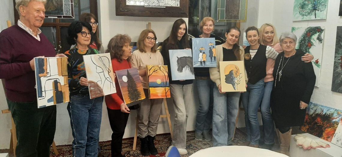 Uczestnicy spotkania „nieWinne malowanie” podczas wspólnego malowania obrazów przy sztalugach w Galerii Studnia