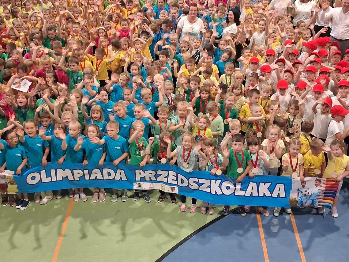 Setki przedszkolaków opanowały halę w Gogolinie. Olimpiada Przedszkolaka 2025 pełna emocji, medali i sportowej zabawy Przedszkolaki podczas Olimpiady Przedszkolaka 2025 w hali sportowej w Gogolinie. Dzieci biorą udział w konkurencjach sportowych i zabawach ruchowych.
