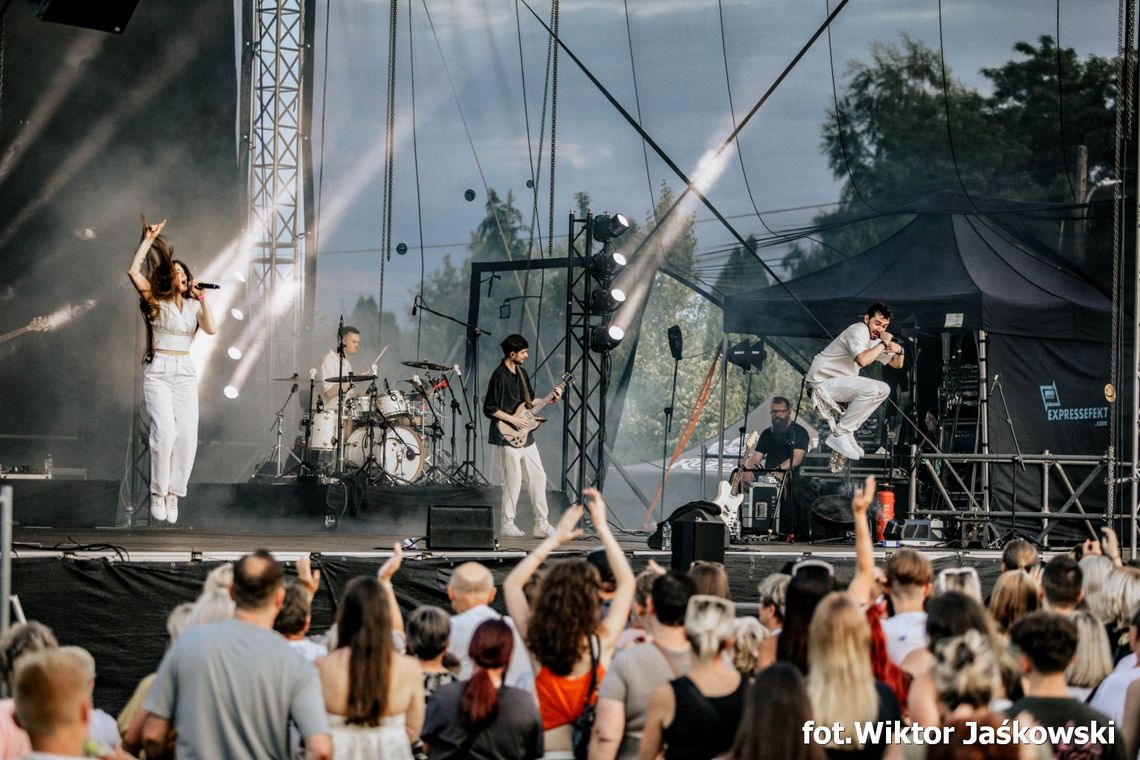 Kamil Bednarek śpiewający na scenie plenerowej podczas Dni Krapkowic 2025, z publicznością oświetloną światłami sceny w tle.