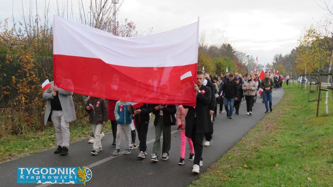 NA ZDJĘCIU Uczestnicy Marszu Narodowej Jedności w Otmęcie 2025 idą Aleją Jana Pawła II z biało-czerwonymi flagami w Święto Niepodległości