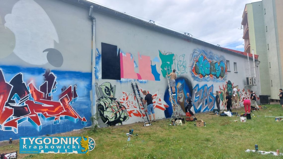 Artysta malujący wielkoformatowy mural inspirowany postaciami Marvela na ścianie budynku w Otmęcie podczas wydarzenia street art.