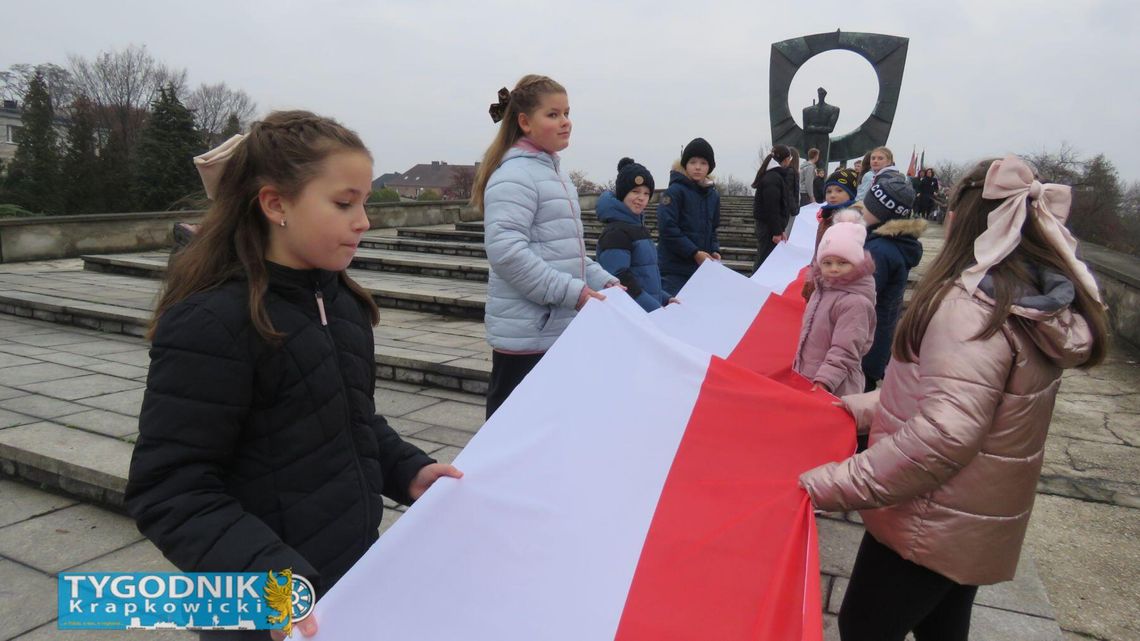 Na zdjęciu Mieszkańcy Zdzieszowic z biało-czerwonymi flagami świętują 11 listopada przy pomniku Powstańca Śląskiego podczas obchodów Święta Niepodległości 2025.