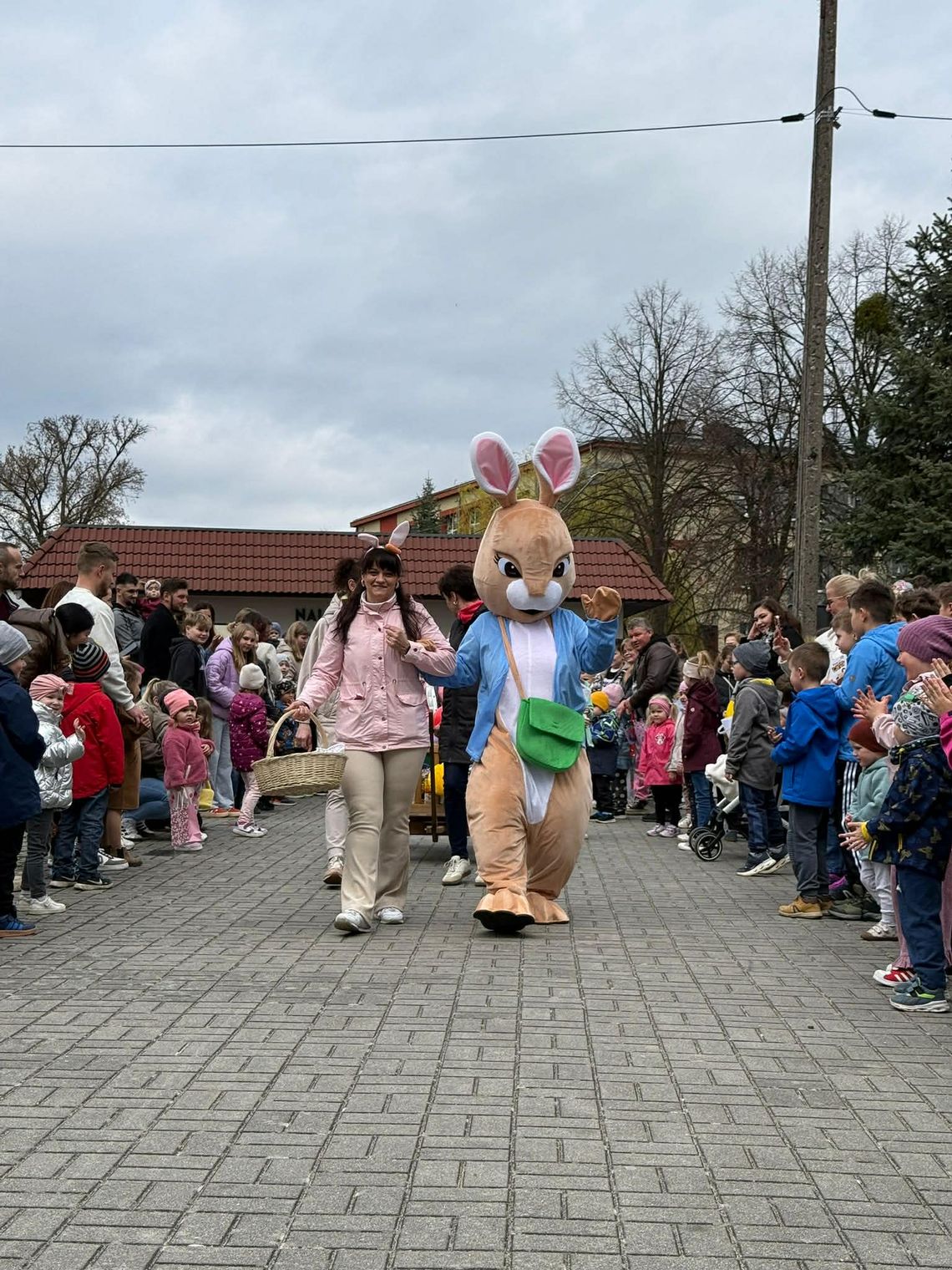 Dzieci odbierające wielkanocne paczki od Zajączka podczas wydarzenia w Kamieniu Śląskim organizowanego przez KGW Kamieńskie Babki
